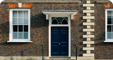 Classic brick house with a navy-blue front door and white-framed windows